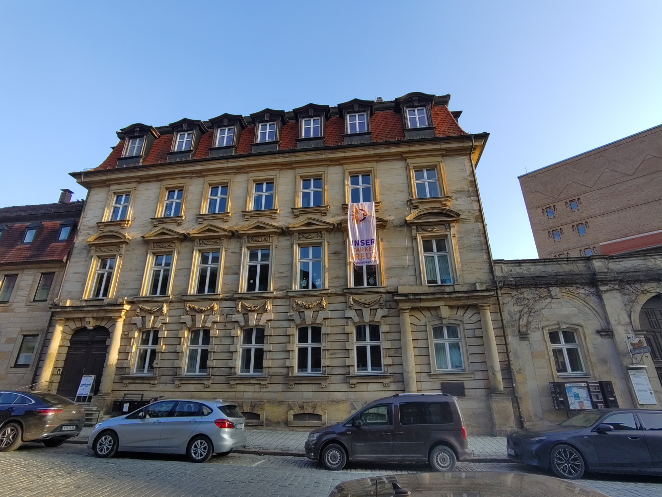 Altes Haus in Bayreuth mit Fahne "Unser sarkes Kreuz für Demokratie"