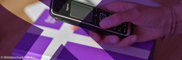 Hand mit Telefon über Bibel